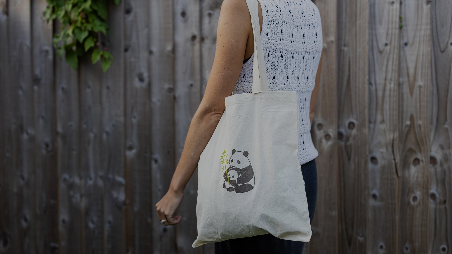 A woman carries a tote bag which has been customised with a panda motif from Creative Park with Canon's iron-on transfers.